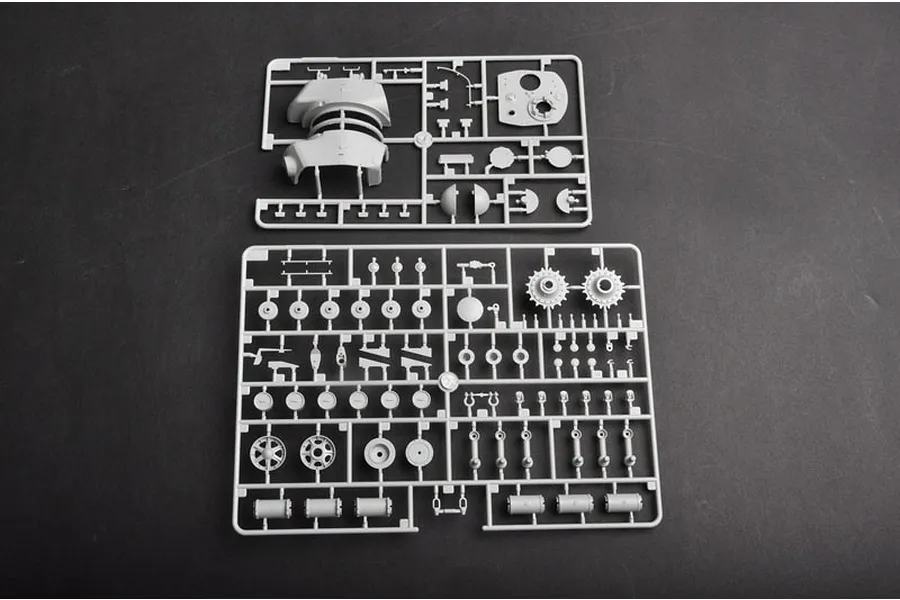 Two grey plastic model kit sprues containing various tank parts laid out on a dark surface.