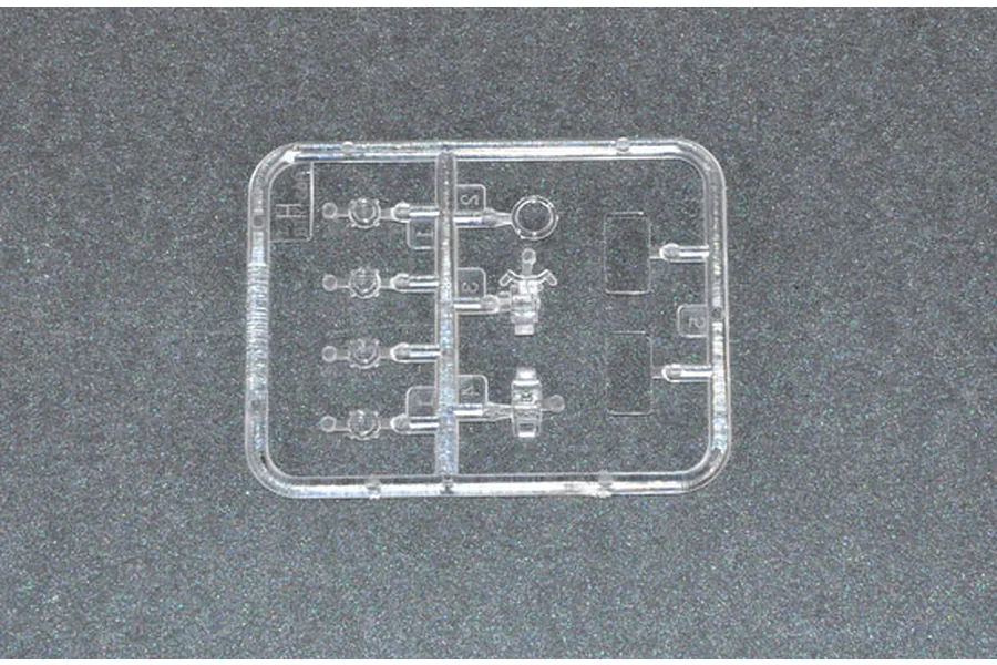 A small clear plastic sprue containing various small parts for a Trumpeter 1/35 scale model kit, set against a dark grey textured background.