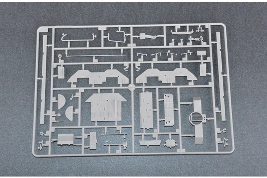 A grey plastic model kit sprue containing various unpainted parts for a 1/35 scale military vehicle model.