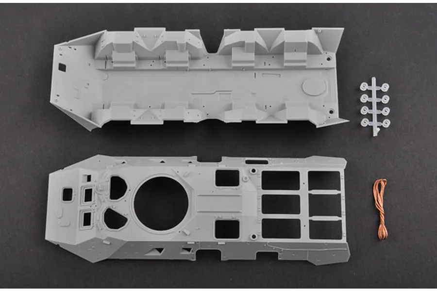 Top-down view of unpainted grey plastic model kit parts for a BTR-80 APC including the hull, interior floor, small sprue, and copper wire.