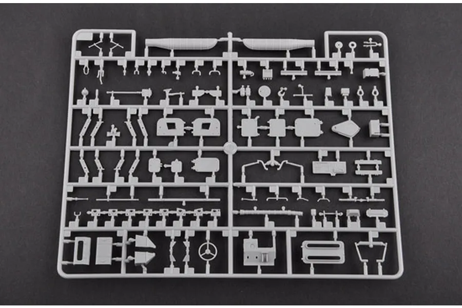 A grey plastic sprue containing various small model parts for a 1/35 scale military vehicle kit, set against a dark grey background.