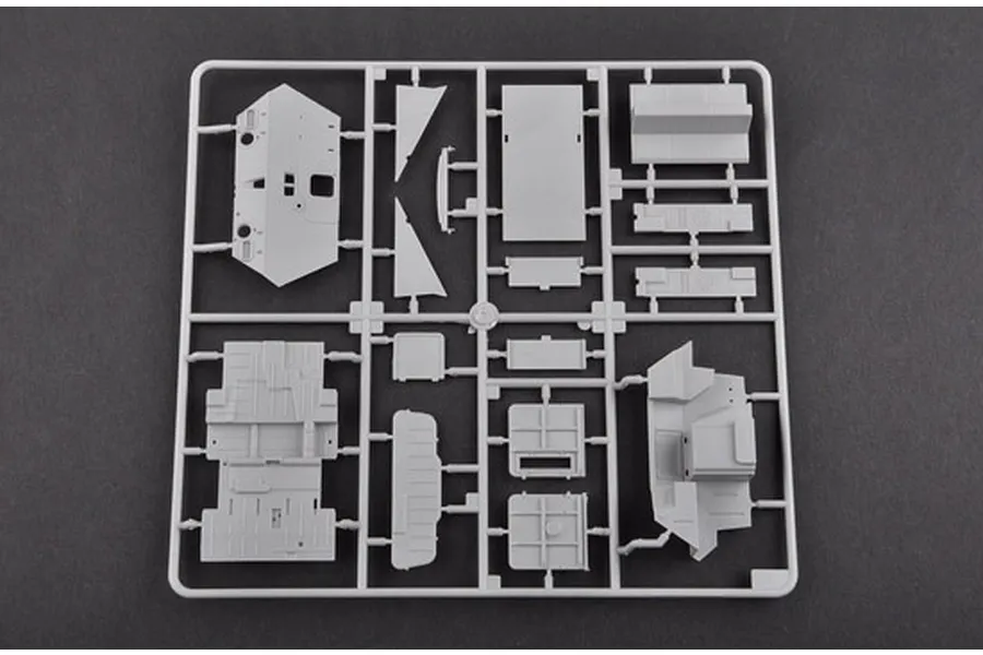 A grey plastic sprue containing various model parts for a 1/35 scale military vehicle kit, set against a dark grey background.