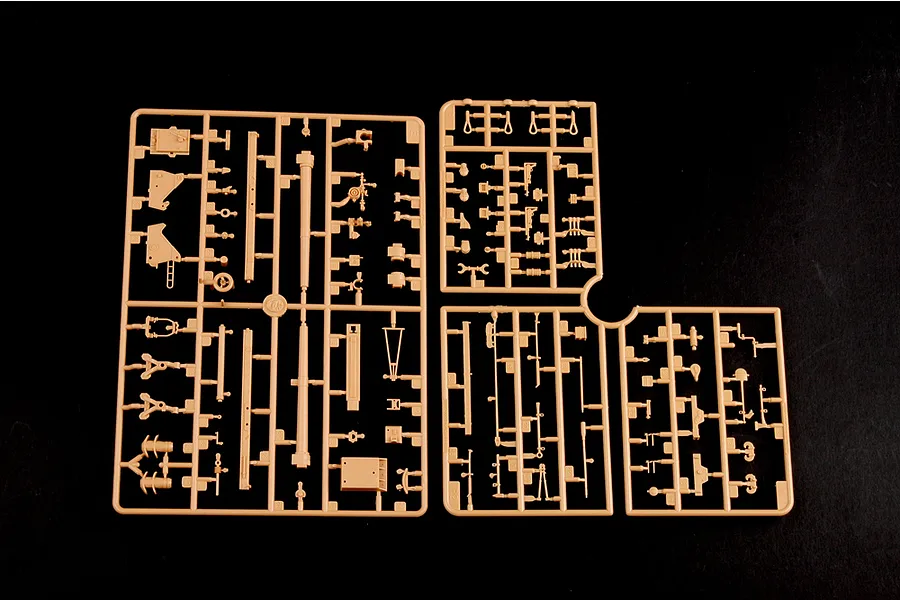 Tan plastic model kit sprues containing various parts for a 1/35 scale military vehicle model on a black background.