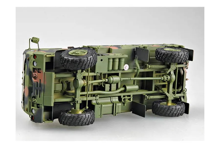 Underside view of a 1/35 scale Trumpeter M1078 military cargo truck model kit showing the chassis, drivetrain, and suspension details.