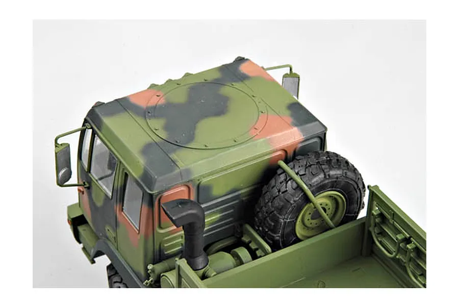 High-angle view of a 1/35 scale model M1078 military cargo truck with camouflage paint, showing the cab roof, spare tire, and cargo bed.