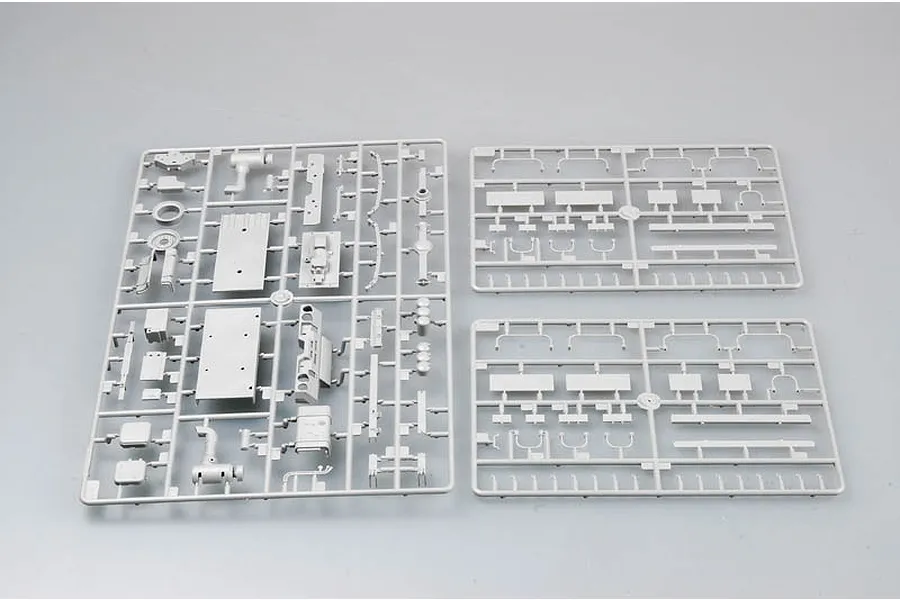 Three grey plastic model kit sprues for a Trumpeter 1/35 scale M1078 truck model, laid out on a plain grey background.