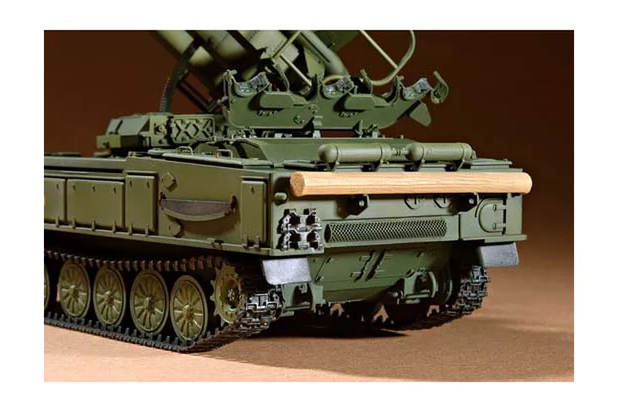 A close-up view of the rear section of a 1/35 scale Russian SAM-6 anti-aircraft missile vehicle model, showing the tracks, hull, and a wooden log detail.