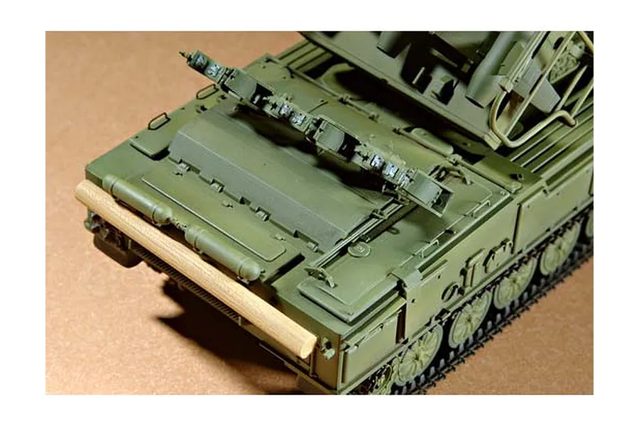 A high-angle close-up of a 1/35 scale Russian SAM-6 anti-aircraft missile model, showing the rear deck, tracks, and a wooden log detail.