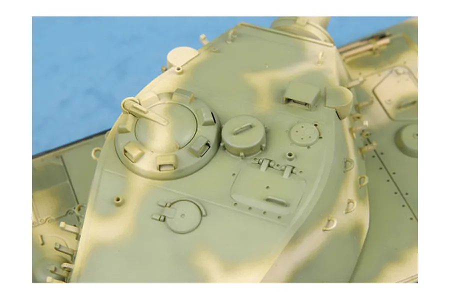 Top-down view of a painted plastic model tank turret with camouflage pattern.