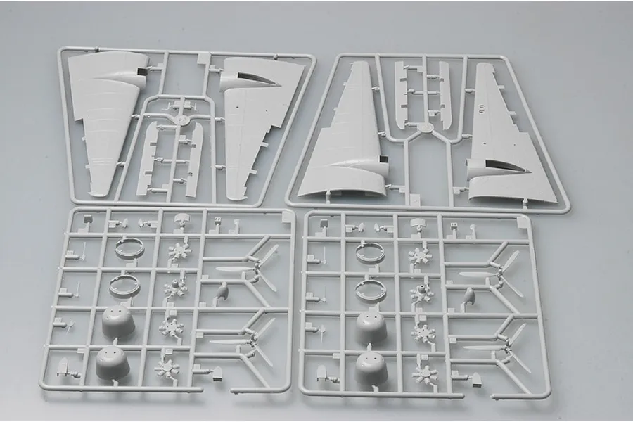 Four grey plastic model kit sprues containing aircraft wing sections, engine cowlings, and propeller parts for a Wellington bomber model.