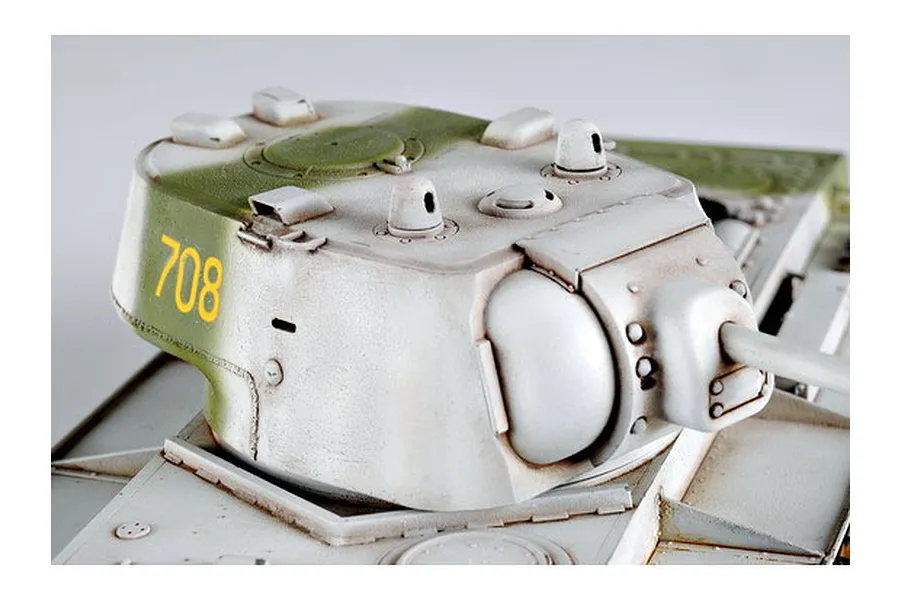 Close-up of a painted KV-1 tank model turret with white winter camouflage and the number 708 in yellow on the side.