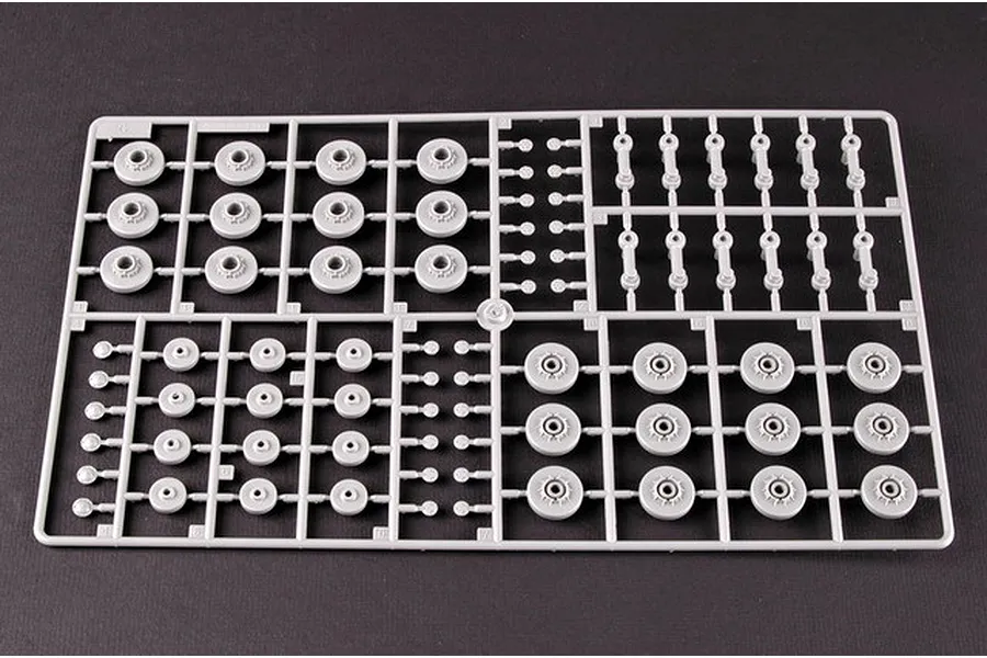 A grey plastic sprue containing various tank road wheels and suspension components for a 1/35 scale model kit.