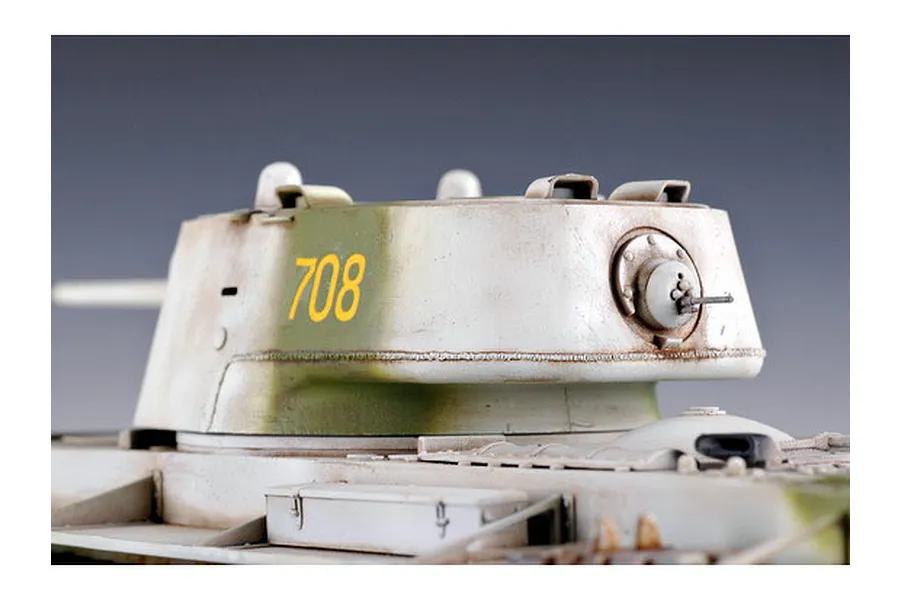 Close-up of a painted scale model KV-1 tank turret with number 708 in yellow, featuring weathered white and green camouflage.