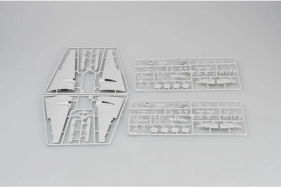 Four grey plastic model kit sprues containing aircraft wing and component parts on a plain background.