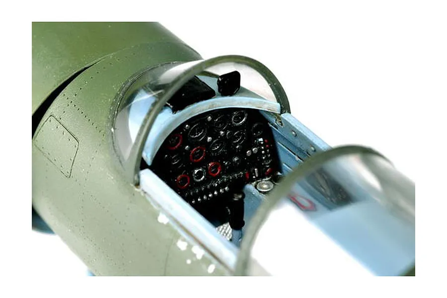Close-up of a 1/32 scale plastic model aircraft cockpit showing the instrument panel and canopy.