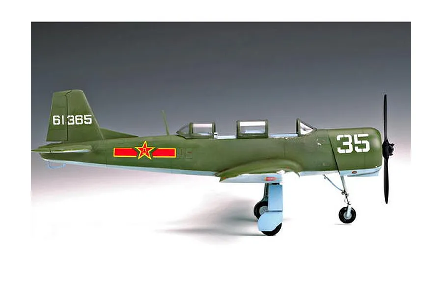 A side-profile view of a 1/32 scale plastic model of a Chinese Nanchang CJ-6 trainer aircraft, painted in olive green with red star markings.