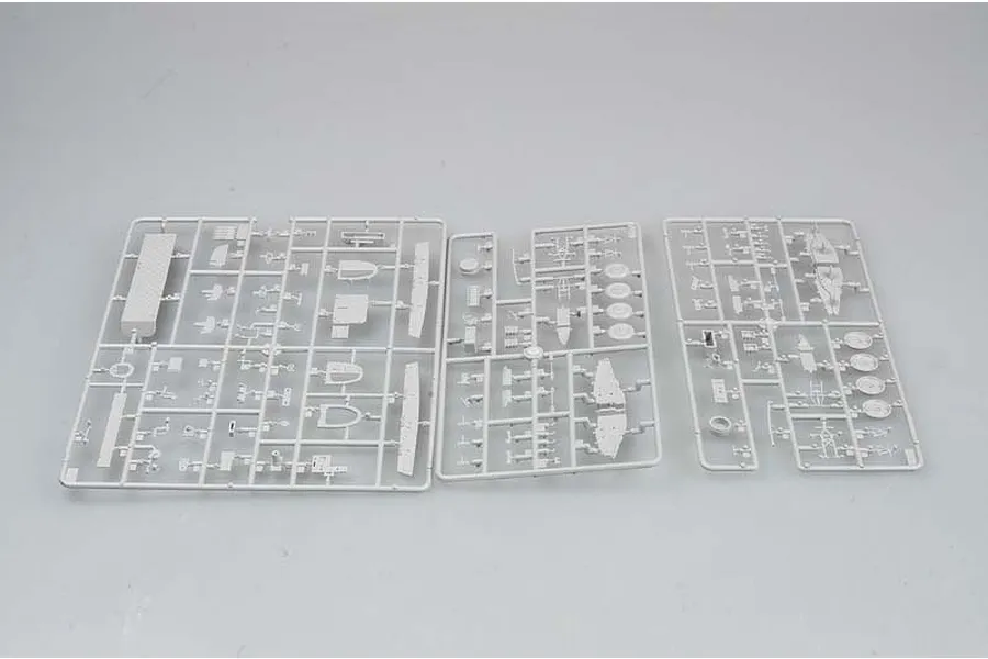 Three grey plastic model kit sprues containing various aircraft parts laid out on a plain light grey background.