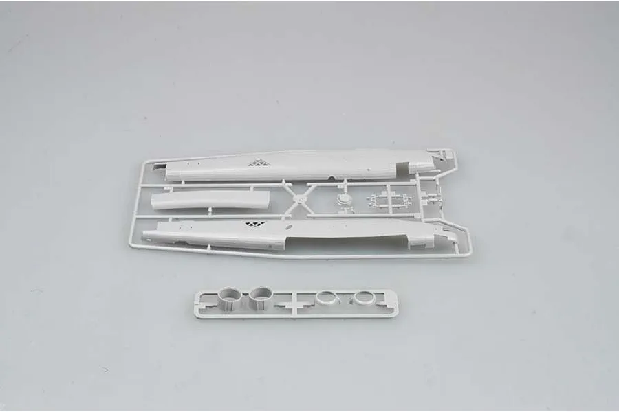 Two grey plastic model kit sprues containing aircraft fuselage halves and engine components on a plain light grey background.