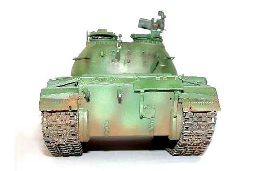 A front-facing view of a painted scale model of a T-54A tank, showing its green camouflage paint scheme and detailed tracks.
