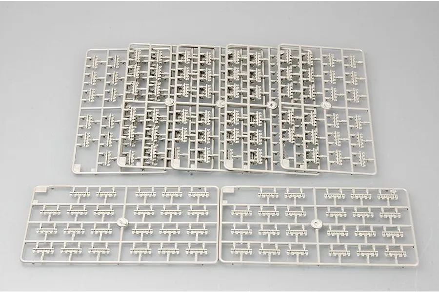 Several grey plastic model kit sprues containing small track link parts for a 1/35 scale military vehicle model.