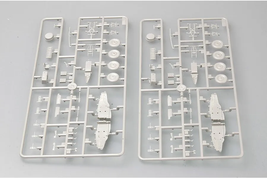 Two identical grey plastic model kit sprues containing various aircraft parts like wheels and fuselage sections.