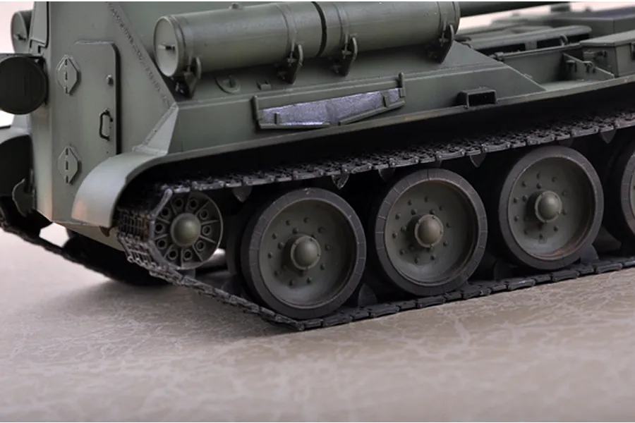 Close-up of the rear side of a green plastic model Soviet SU-101 self-propelled gun, showing the tracks, road wheels, and fuel tanks.