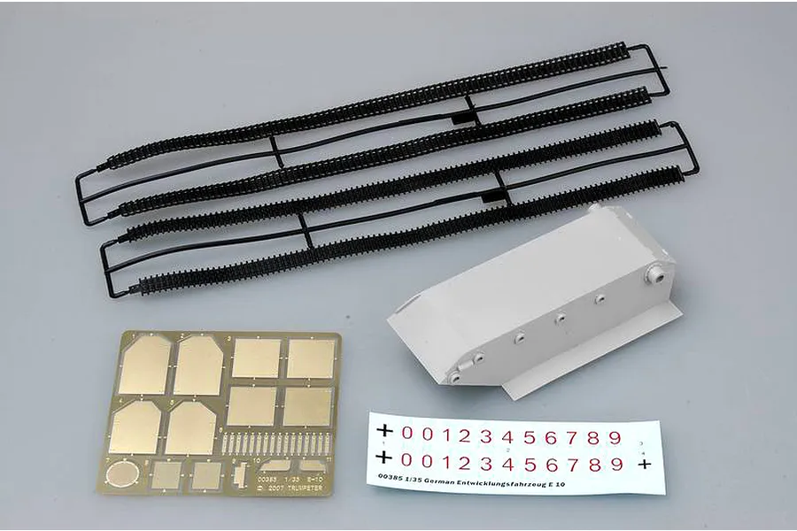 Trumpeter 1/35 scale model kit parts including black plastic tank tracks, a grey plastic hull section, a photo-etched brass fret, and a decal sheet.