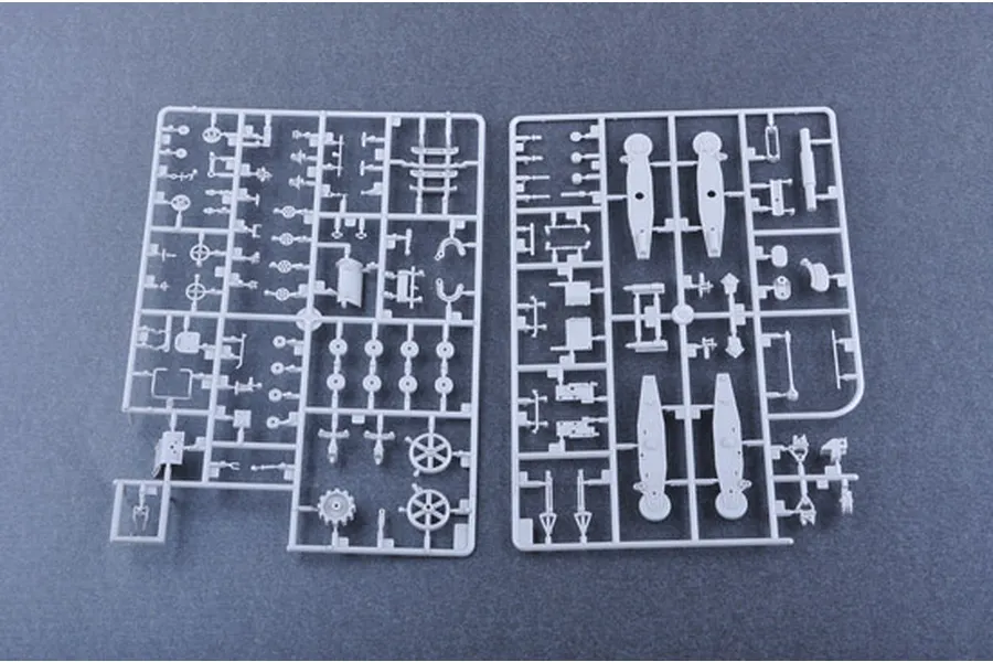 Two grey plastic model kit sprues containing various small parts for a 1/35 scale military vehicle model, laid out on a dark grey surface.