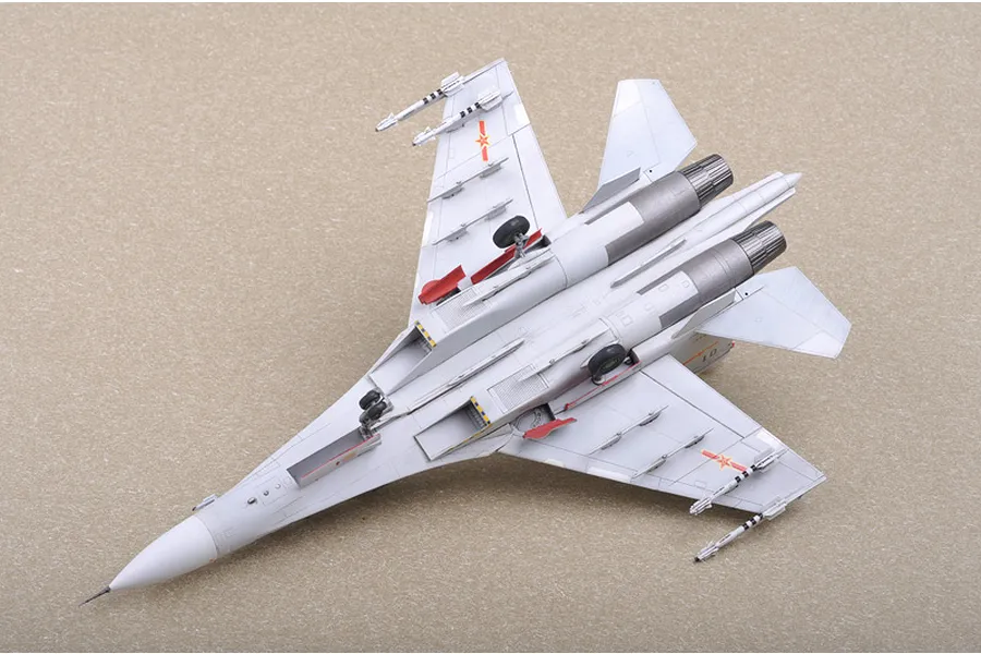 A high-angle view of a completed 1/72 scale plastic model of a Russian Su-30MKK fighter jet, showing the underside with landing gear and missiles.