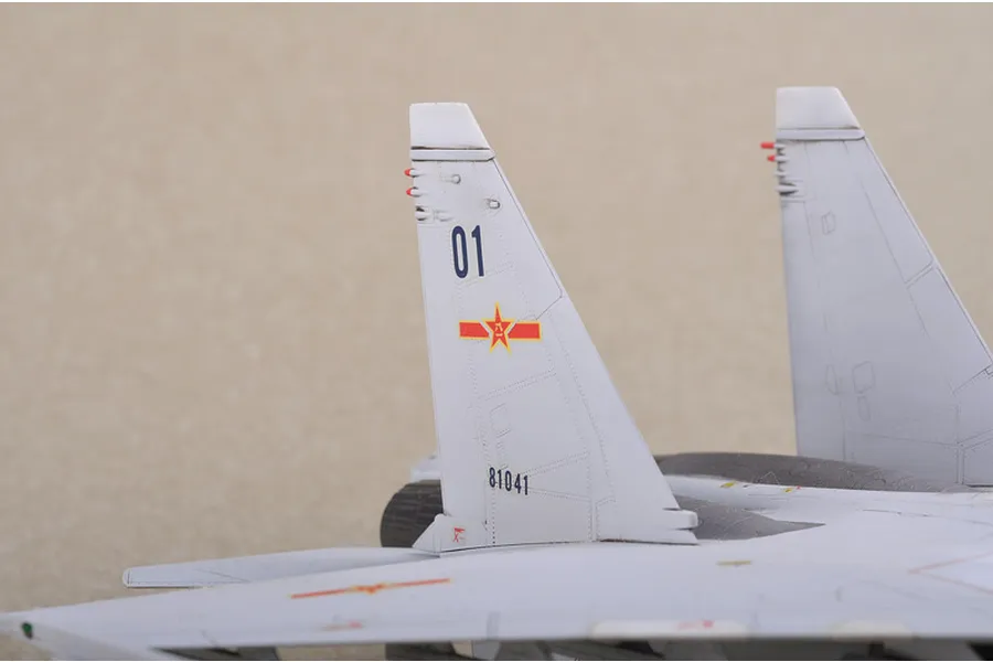 Close-up of the vertical stabilizers on a scale model Su-30MKK fighter jet, featuring Chinese Air Force markings and the number 01.