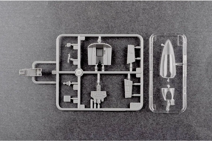 Plastic model kit sprues for a 1/48 scale aircraft, showing cockpit components and a clear canopy part on a dark grey background.
