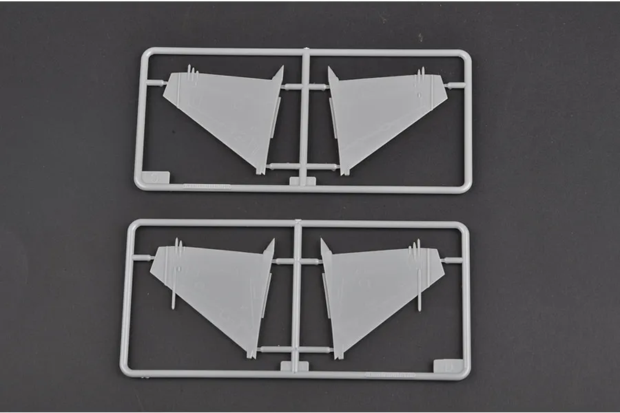 Two grey plastic model kit sprues containing aircraft wing parts on a dark grey background.