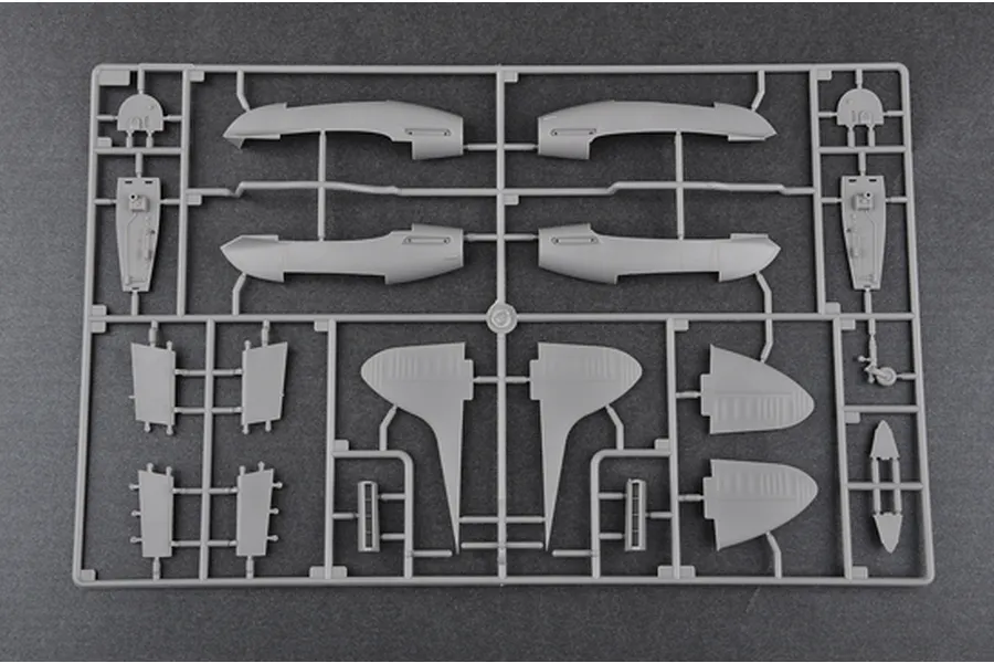 A grey plastic sprue containing various aircraft model parts including fuselage halves, wing sections, and landing gear components.
