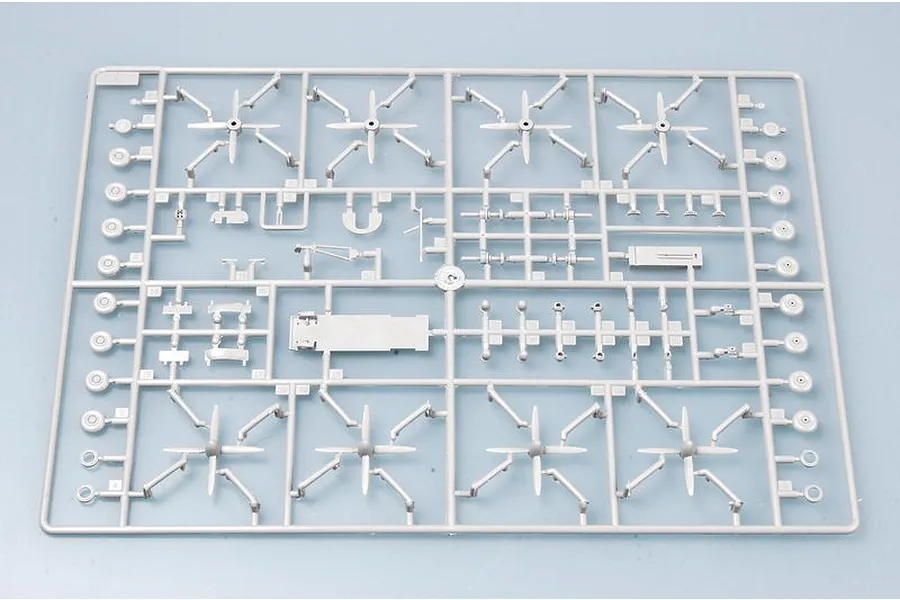 A grey plastic model kit sprue containing various aircraft parts including propellers and landing gear components for a 1/144 scale model.