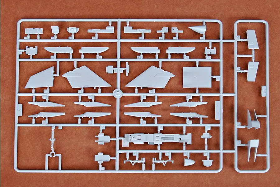 A grey plastic sprue containing various aircraft model parts for a Trumpeter 1/72 scale RA-5C Vigilante kit, laid out on a brown surface.