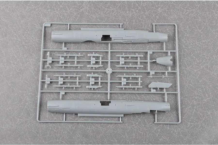 A grey plastic sprue from a Trumpeter 1/48 scale J-7G model kit, featuring two fuselage halves and various small aircraft components.