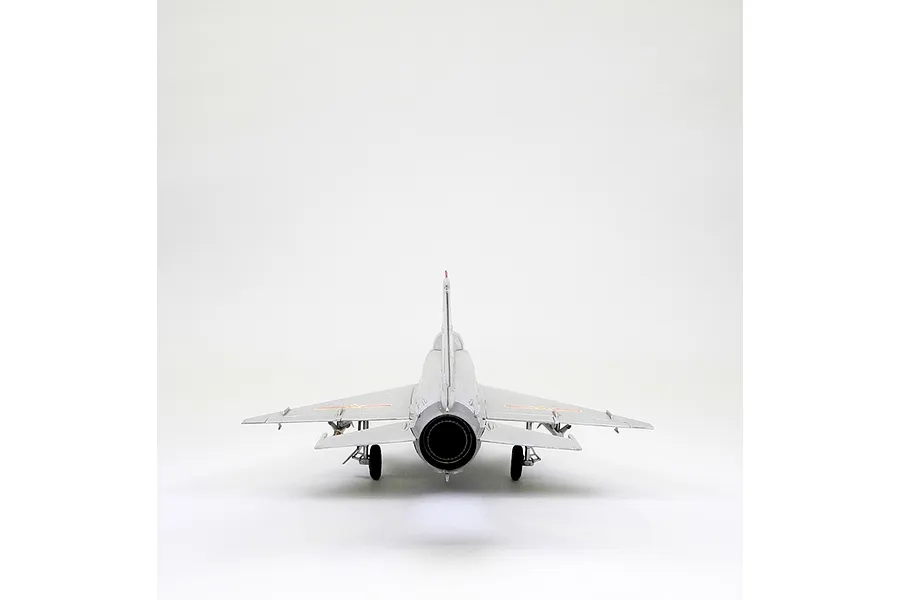 Rear view of a silver MiG-21F-13 model aircraft showing the engine exhaust nozzle, landing gear, and delta wings against a white background.