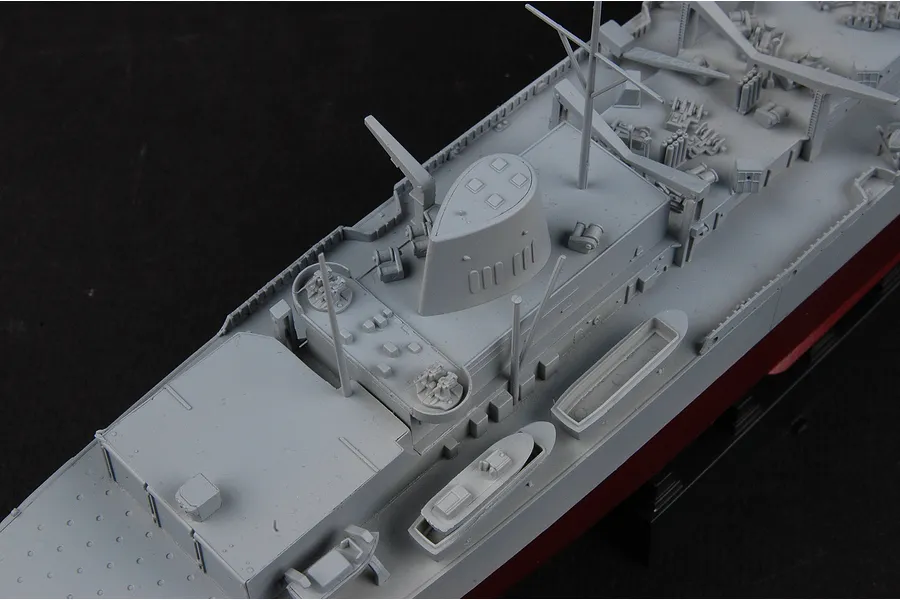 High angle close-up of a grey plastic model battleship deck showing the superstructure, funnel, and small lifeboats.