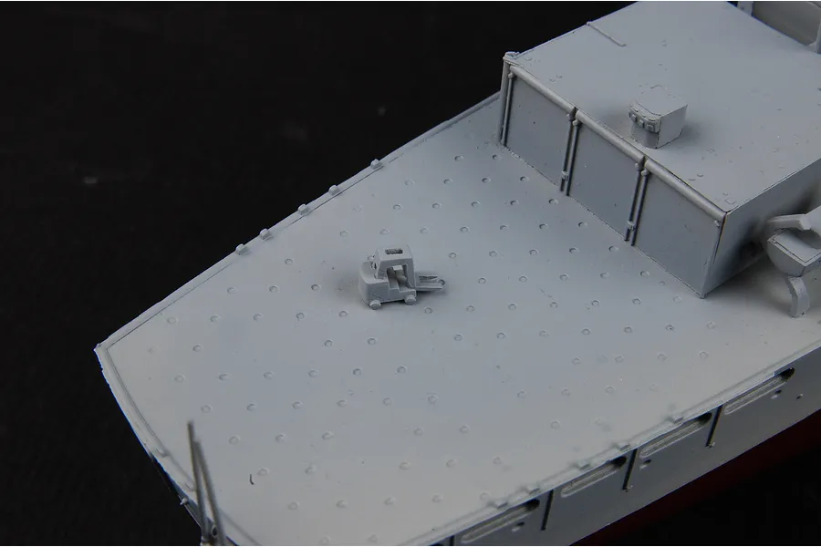 Close-up of a 1/700 scale model battleship deck showing a small forklift on the deck surface.