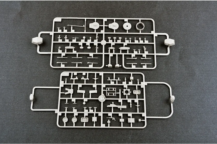 Two light grey plastic model kit sprues containing various small ship parts, laid out on a dark grey surface.