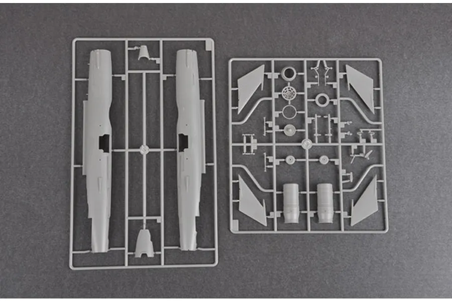 Two grey plastic model kit sprues containing fuselage and wing parts for a 1/48 scale J-7B fighter jet model.