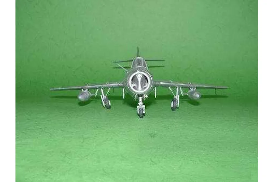 Front view of a finished 1/48 scale MiG-15 UTI Midget model aircraft on a green background.