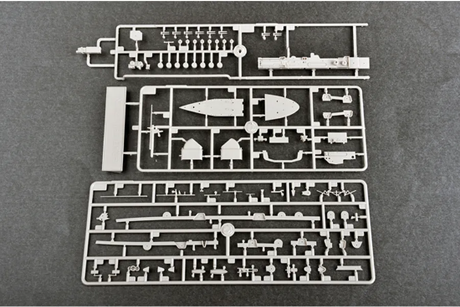 Three grey plastic model kit sprues containing various ship parts laid out on a dark grey surface.