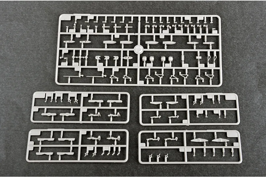 Five grey plastic model kit sprues containing small aircraft parts for a 1/700 scale model, laid out on a dark grey surface.
