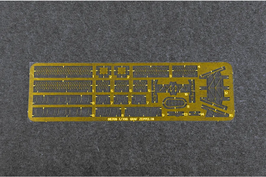A photo-etched brass fret for a 1/700 scale Trumpeter Graf Zeppelin model kit, featuring various railings and structural parts on a grey felt background.