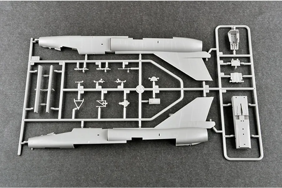 A grey plastic model kit sprue containing fuselage halves and small aircraft components for a 1/72 scale model jet.