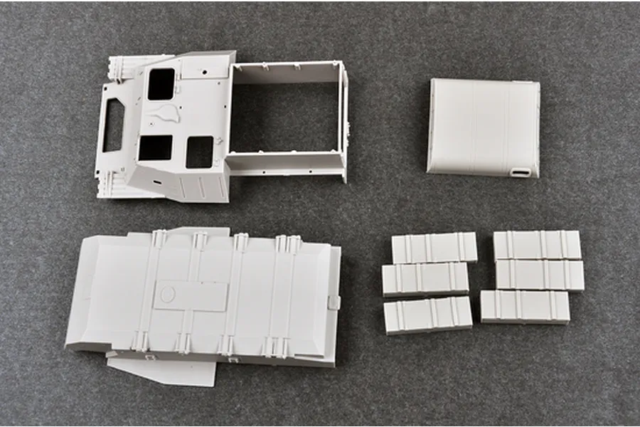 Unassembled grey plastic model kit parts for a 1/35 scale Soviet AT-P artillery tractor, including the main hull and roof sections.