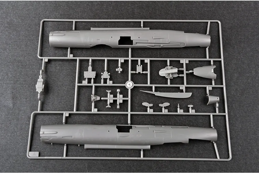 A grey plastic sprue containing model aircraft fuselage halves and various small components for the Trumpeter 1/48 J-7A fighter jet model kit.
