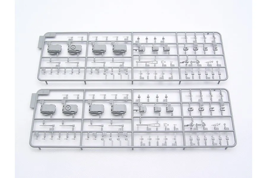 Two identical grey plastic model kit sprues containing battleship turret and armament parts on a white background.