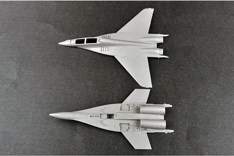 Top and bottom views of unpainted grey plastic model aircraft fuselage parts for a MiG-29UB fighter jet kit.